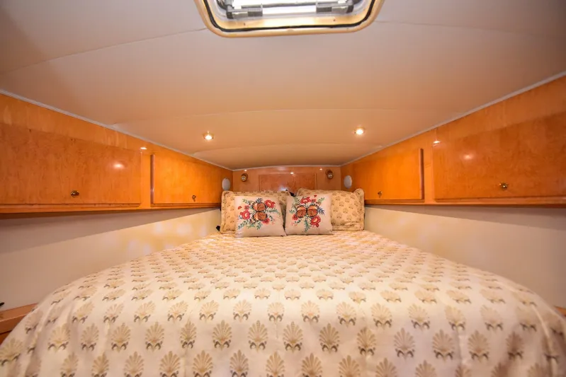 Next Chapter Yacht Photos Pics Cozy bedroom in 2004 Navigator Rival yacht with wood cabinets and floral bedding.