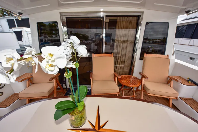 Next Chapter Yacht Photos Pics Luxurious 2004 Navigator Rival yacht deck with elegant seating and orchid centerpiece.