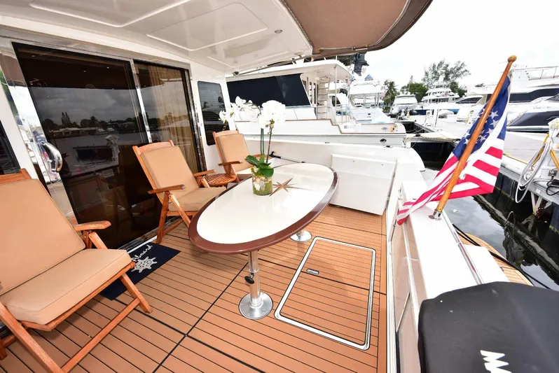 Next Chapter Yacht Photos Pics Luxurious 2004 Navigator Rival yacht deck with seating, table, and American flag.