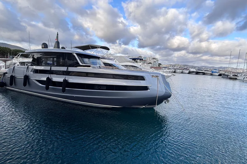  Yacht Photos Pics Luxury 2026 Invictus ST 550 yacht docked in a serene marina under cloudy skies.
