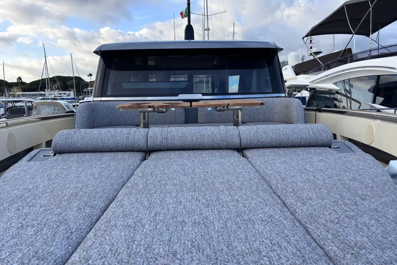  Yacht Photos Pics 2026 Invictus ST 550 yacht with luxurious deck seating and table, docked at marina.