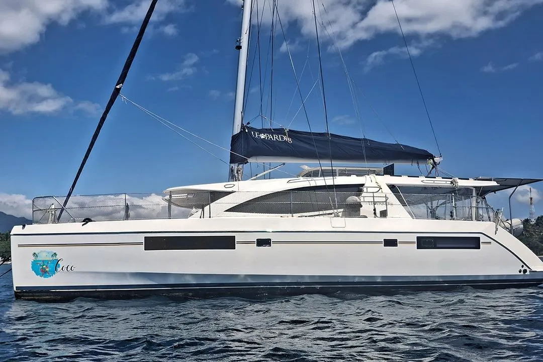 2013 Leopard 48 catamaran sailing on open water under a clear blue sky.