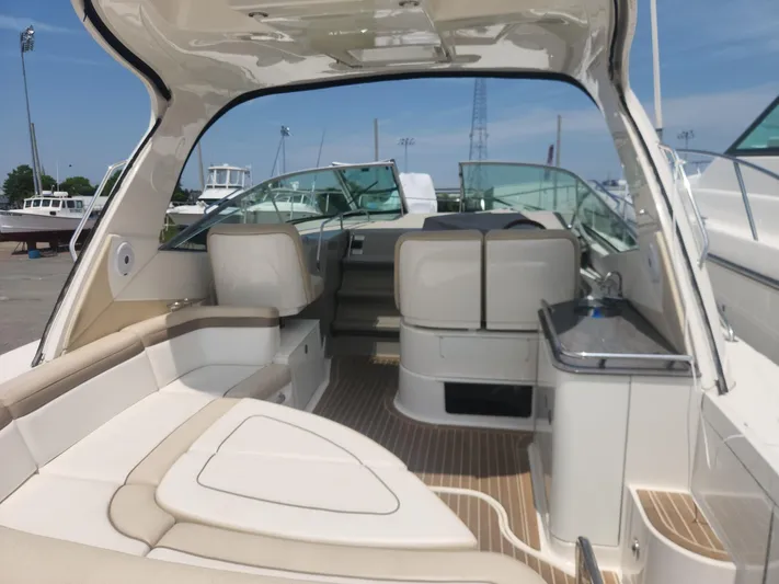  Yacht Photos Pics 2013 Sea Ray 370 Sundancer boat interior with seating and helm, docked under clear sky.