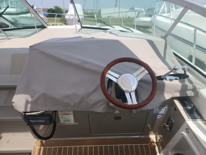  Yacht Photos Pics Helm of 2013 Sea Ray 370 Sundancer with covered dashboard and wooden steering wheel.