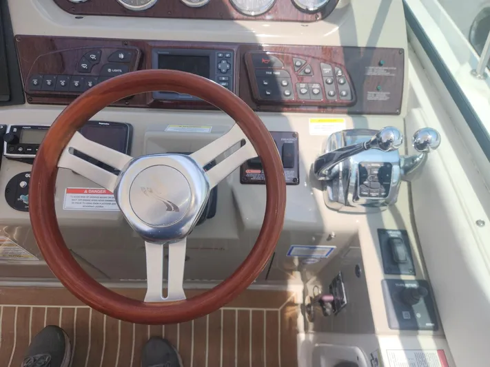  Yacht Photos Pics Control panel of a 2013 Sea Ray 370 Sundancer boat with wooden steering wheel.