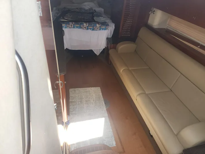  Yacht Photos Pics Interior of 2013 Sea Ray 370 Sundancer with beige sofa and bed in view.