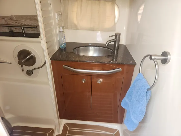  Yacht Photos Pics 2013 Sea Ray 370 Sundancer bathroom with sink, wooden cabinet, and towel holder.