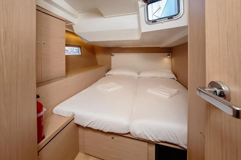  Yacht Photos Pics Cozy cabin interior of 2018 Beneteau Oceanis 51.1 yacht with double bed and wooden finish.