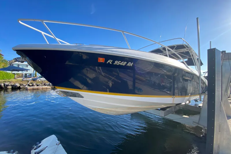  Yacht Photos Pics 2004 Deep Impact 36 DI boat on lift, sunny day, waterfront view.