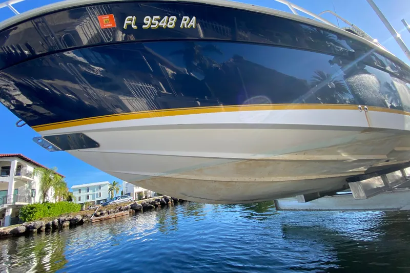  Yacht Photos Pics 2004 Deep Impact 36 DI boat on lift, reflecting water and buildings.