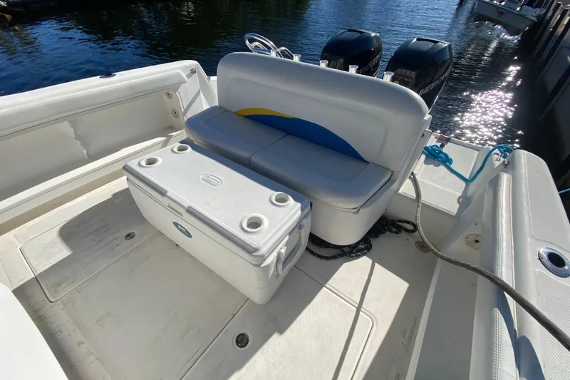  Yacht Photos Pics 2004 Deep Impact 36 DI boat interior with seating and cooler, docked by the water.