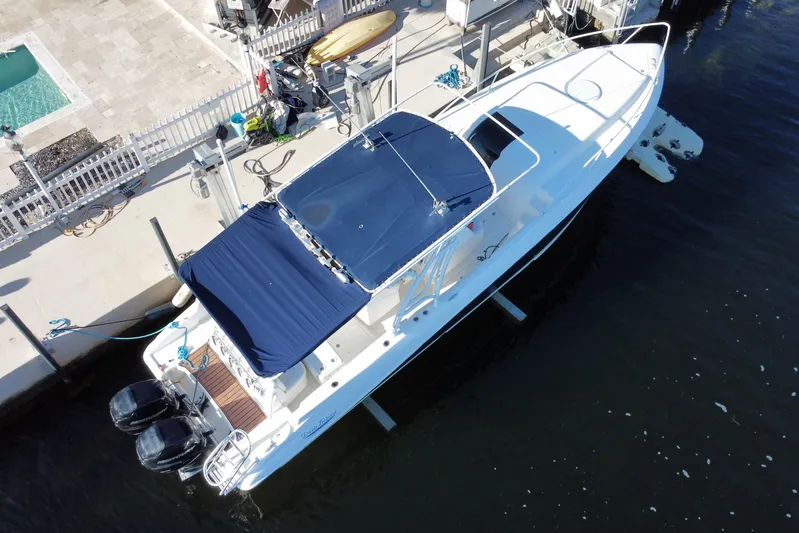  Yacht Photos Pics 2004 Deep Impact 36 DI boat docked, featuring dual engines and blue canopy.