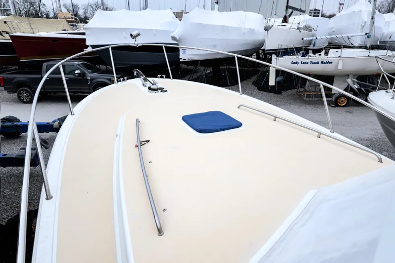 Staying Stoked Yacht Photos Pics 2005 MJM 34z Downeast boat on land, surrounded by other covered boats.