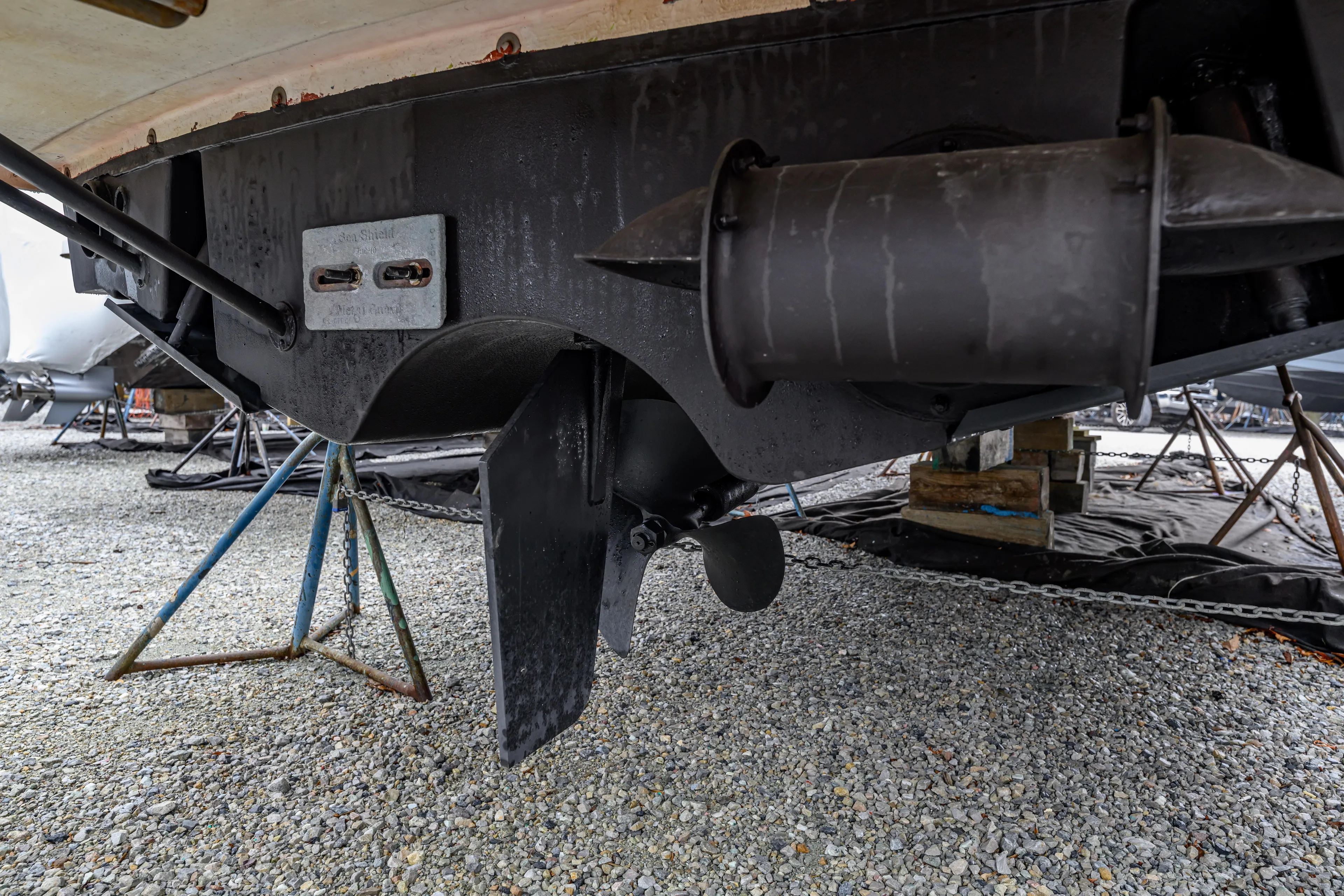 Staying Stoked Yacht Photos Pics 2005 MJM 34z Downeast boat underside with propeller and rudder on gravel.