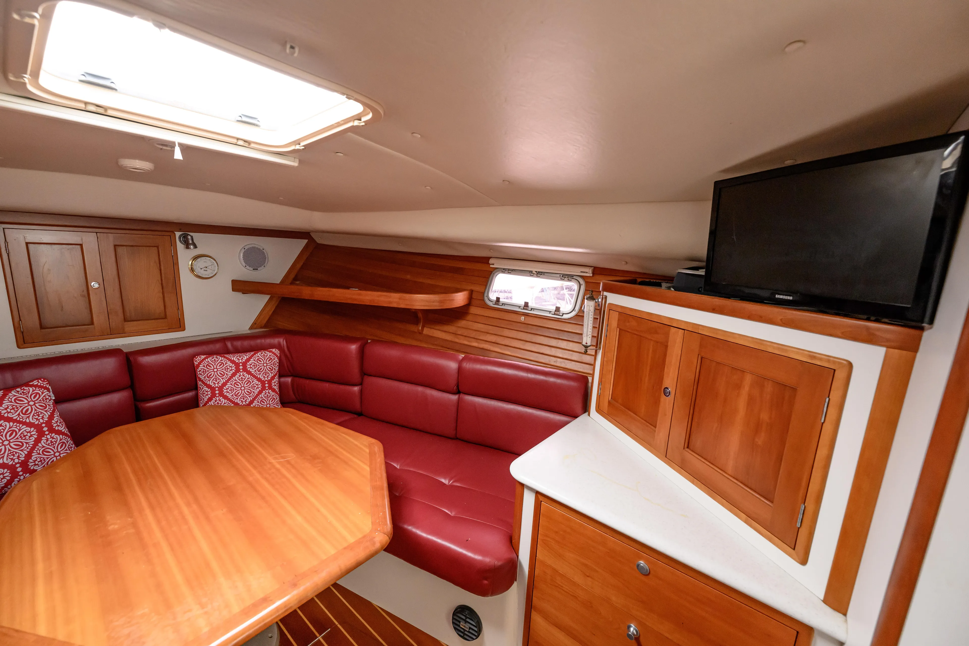 Staying Stoked Yacht Photos Pics 2005 MJM 34z Downeast yacht interior with red seating, wooden table, and TV.