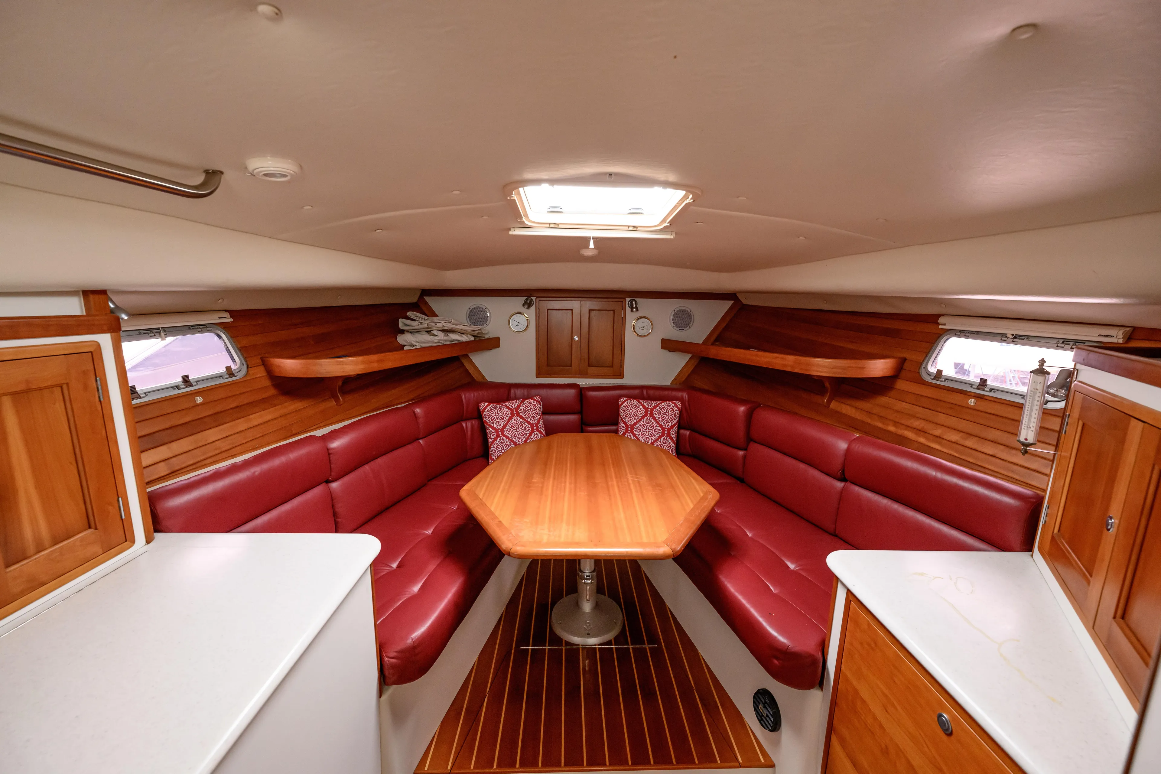 Staying Stoked Yacht Photos Pics 2005 MJM 34z Downeast yacht interior with red leather seating and wooden table.