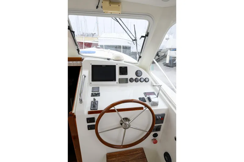 Staying Stoked Yacht Photos Pics 2005 MJM 34z Downeast boat helm with wooden steering wheel and navigation instruments.