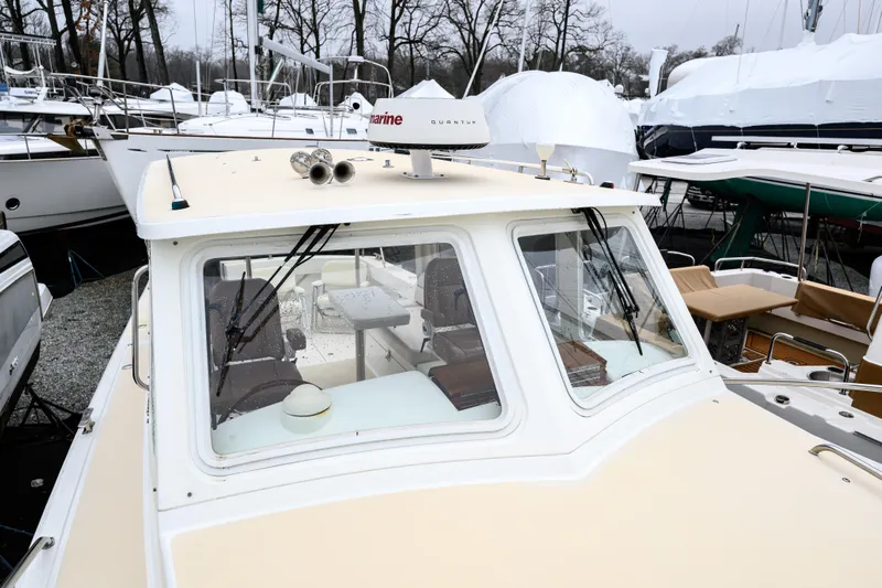 Staying Stoked Yacht Photos Pics 2005 MJM 34z Downeast boat in marina, surrounded by other vessels and covered structures.