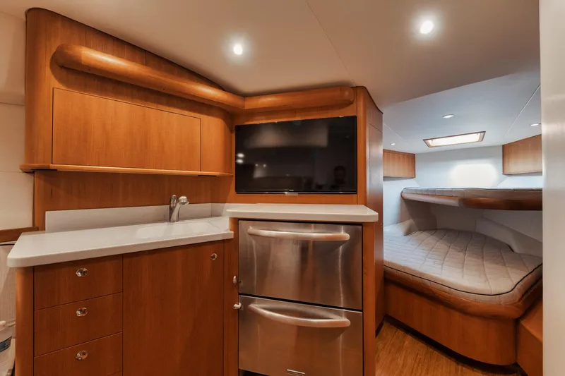 Dog House Yacht Photos Pics Luxurious 2016 F&S Express yacht interior with wood cabinetry, stainless appliances, and cozy sleeping area.