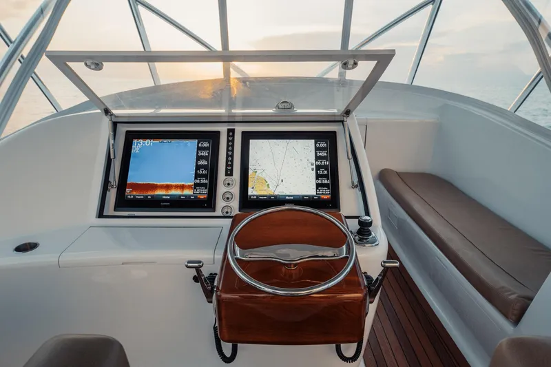 Dog House Yacht Photos Pics Cockpit of 2016 F&S Express boat with navigation screens and wooden steering wheel.