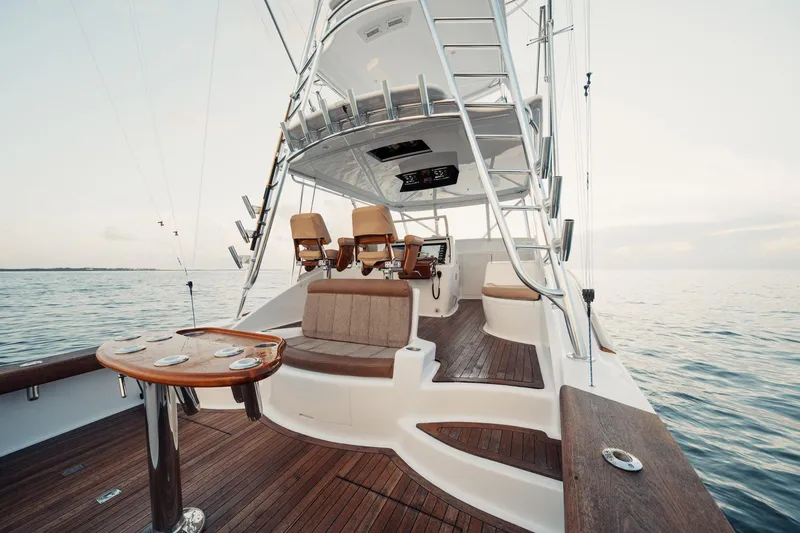 Dog House Yacht Photos Pics 2016 F&S Express yacht interior with wooden deck and seating, overlooking calm ocean waters.