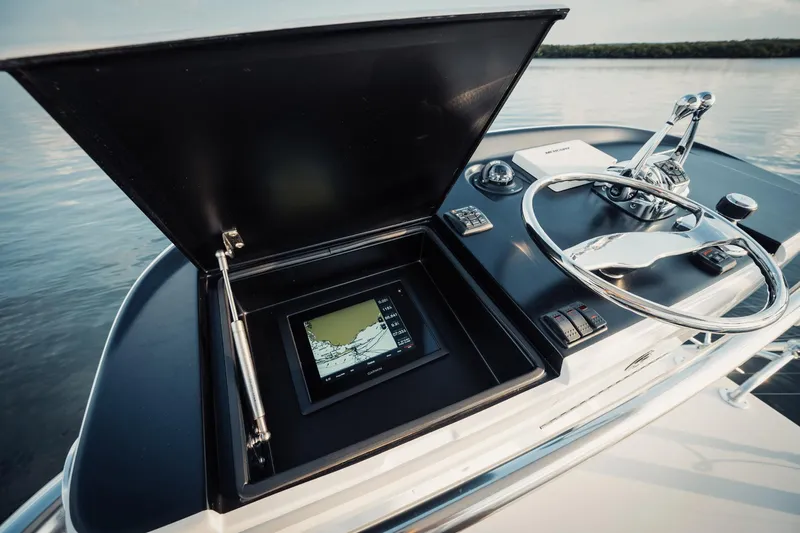 Dog House Yacht Photos Pics Control panel of a 2016 F&S Express boat with navigation display and steering wheel.