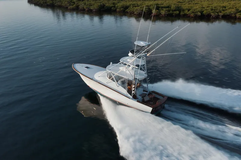 Dog House Yacht Photos Pics 2016 F&S Express boat cruising on calm water near lush shoreline.