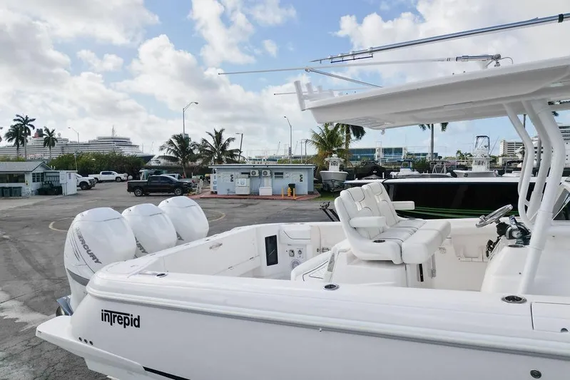  Yacht Photos Pics 2022 Intrepid 345 Nomad FE boat with twin Mercury engines docked at a marina.