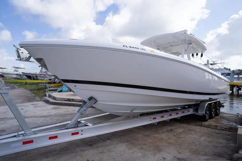  Yacht Photos Pics 2022 Intrepid 345 Nomad FE boat on trailer, ready for launch under a cloudy sky.