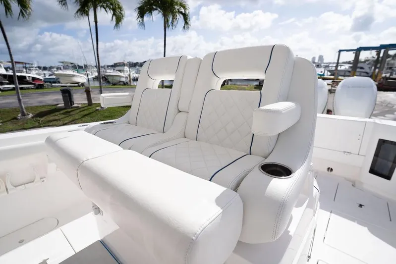  Yacht Photos Pics Luxurious seating on 2022 Intrepid 345 Nomad FE boat, featuring white upholstery and cup holders.