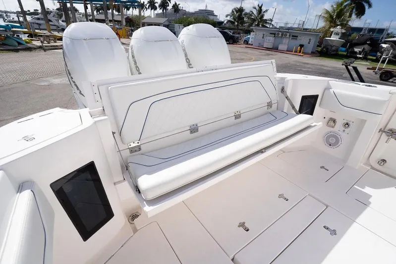  Yacht Photos Pics 2022 Intrepid 345 Nomad FE boat with seating and triple engines at a marina.