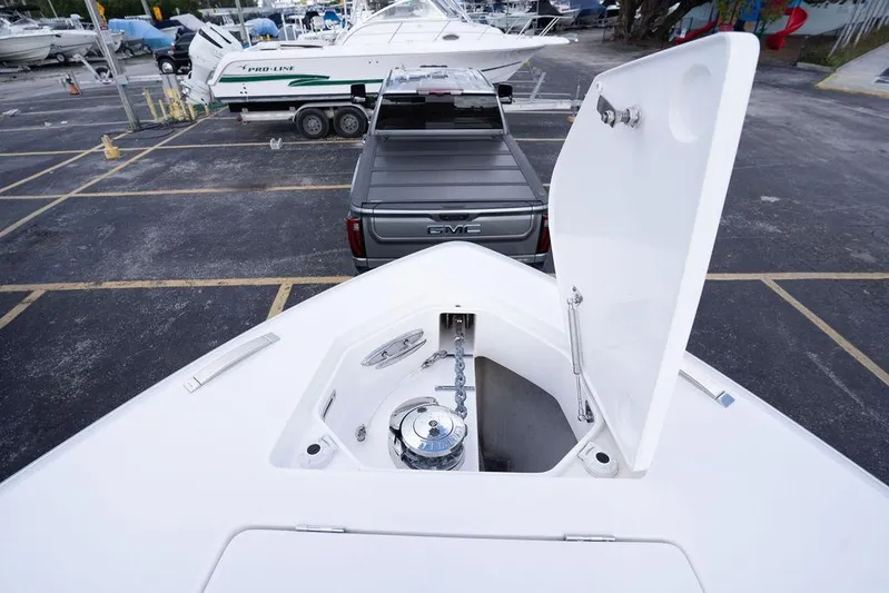  Yacht Photos Pics 2022 Intrepid 345 Nomad FE boat with open anchor compartment in a parking lot.