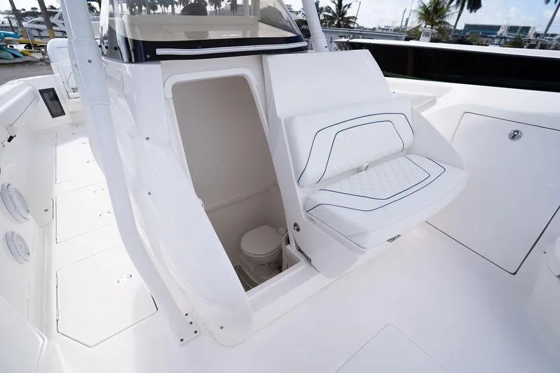  Yacht Photos Pics 2022 Intrepid 345 Nomad FE boat interior with seating and hidden toilet compartment.
