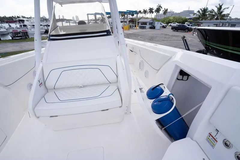  Yacht Photos Pics 2022 Intrepid 345 Nomad FE boat interior with white seating and storage compartment.