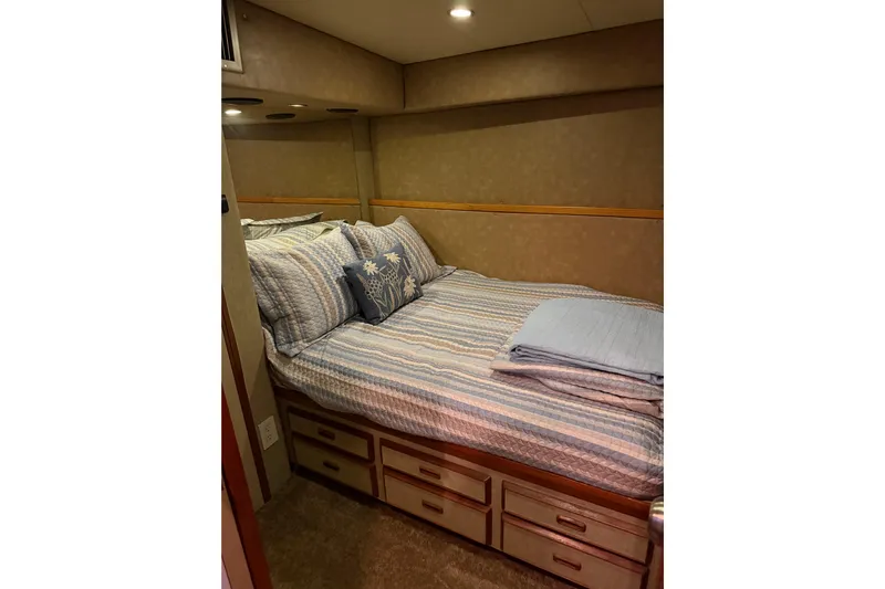 Unbelievable Yacht Photos Pics Cozy bedroom in 1984 Bertram 42 Convertible yacht with striped bedding and storage drawers.