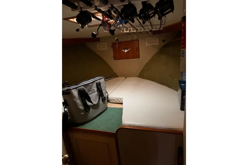 Unbelievable Yacht Photos Pics Cozy cabin interior of 1984 Bertram 42 Convertible with fishing rods and gear.