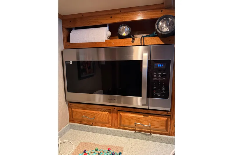 Unbelievable Yacht Photos Pics Microwave in 1984 Bertram 42 Convertible kitchen with wooden cabinetry and countertop.