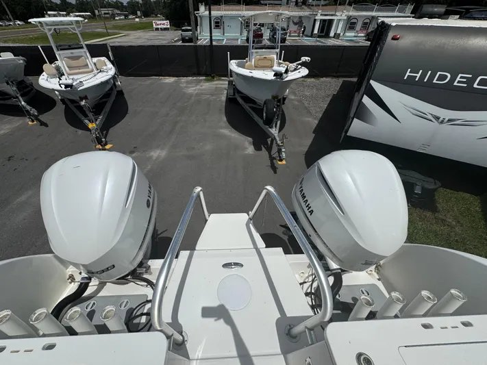  Yacht Photos Pics 2019 World Cat 3200 boat with Yamaha engines, parked near other boats and a trailer.