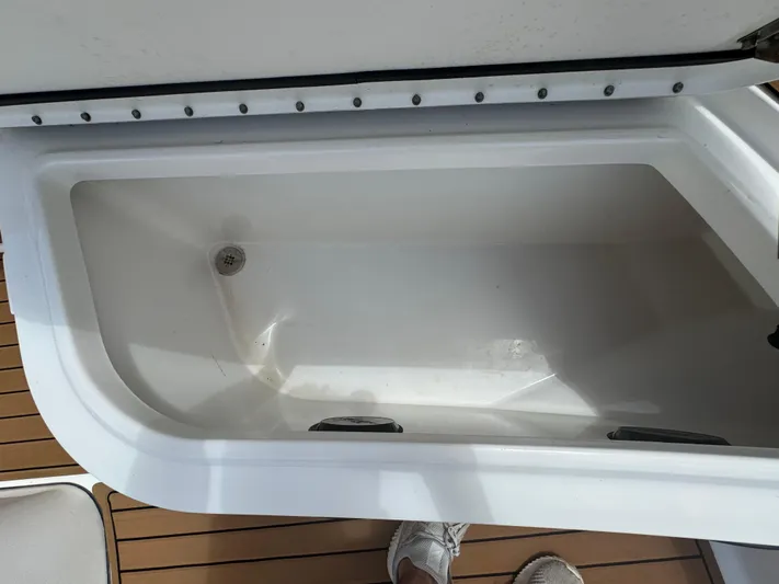  Yacht Photos Pics Open storage compartment on 2019 World Cat 3200 boat, featuring white interior and wooden deck.