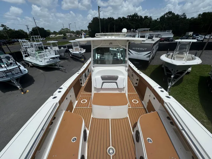  Yacht Photos Pics 2019 World Cat 3200 boat with spacious deck, surrounded by other boats and trailers.