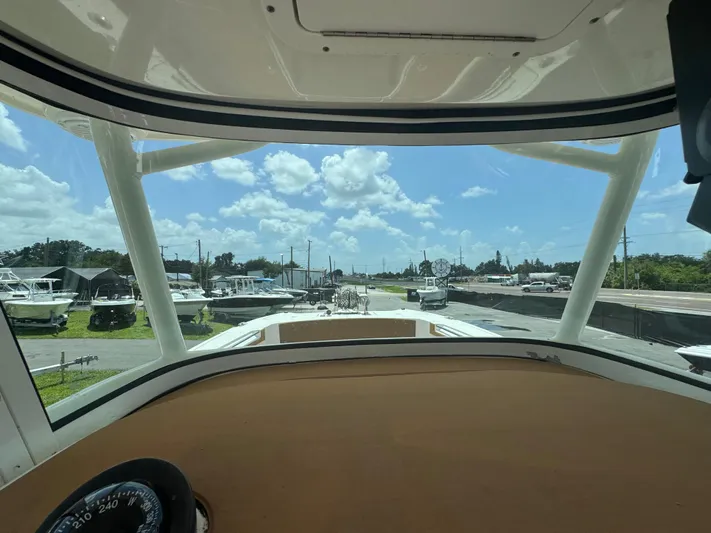  Yacht Photos Pics View from 2019 World Cat 3200 boat cockpit, overlooking marina with multiple boats under a blue sky.