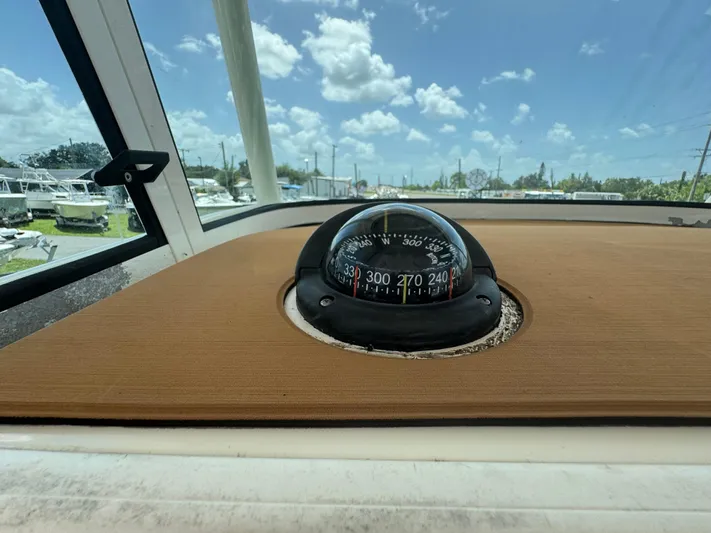  Yacht Photos Pics Compass on 2019 World Cat 3200 boat dashboard under clear blue sky.