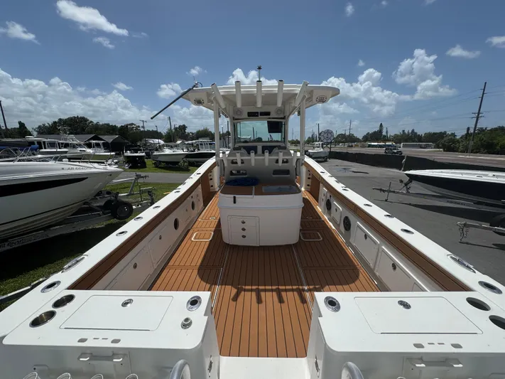  Yacht Photos Pics 2019 World Cat 3200 boat with spacious deck, docked under a clear blue sky.