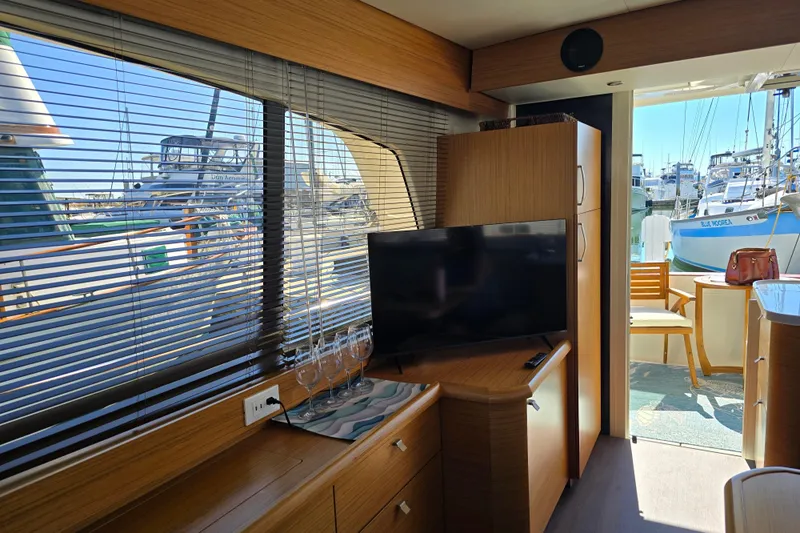  Yacht Photos Pics Interior of 2020 Greenline 40 yacht with TV, wooden cabinets, and marina view.