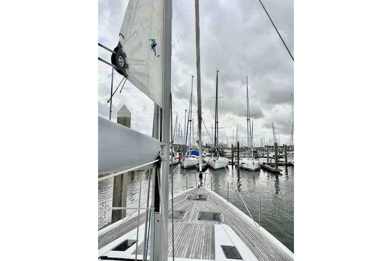 Sea Dawgs Yacht Photos Pics 2021 Beneteau Oceanis Yacht 54 docked in a marina under cloudy skies.