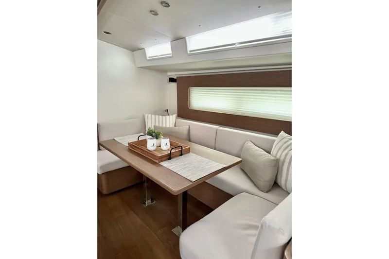 Sea Dawgs Yacht Photos Pics Elegant interior of 2021 Beneteau Oceanis Yacht 54 with cozy seating and modern decor.