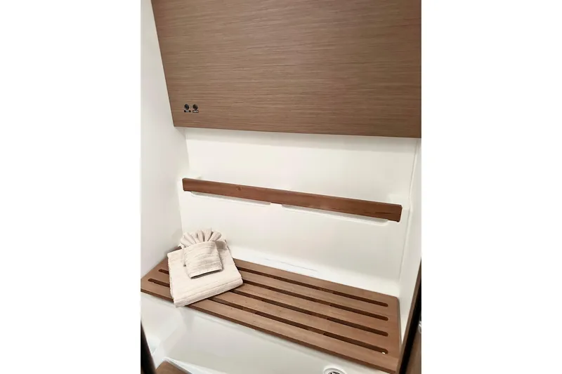 Sea Dawgs Yacht Photos Pics Interior of 2021 Beneteau Oceanis Yacht 54, featuring wooden bench and folded towels.