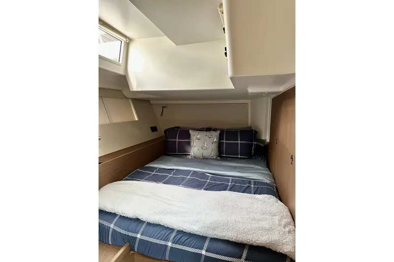 Sea Dawgs Yacht Photos Pics Cozy cabin interior of 2021 Beneteau Oceanis Yacht 54 with nautical-themed bedding.