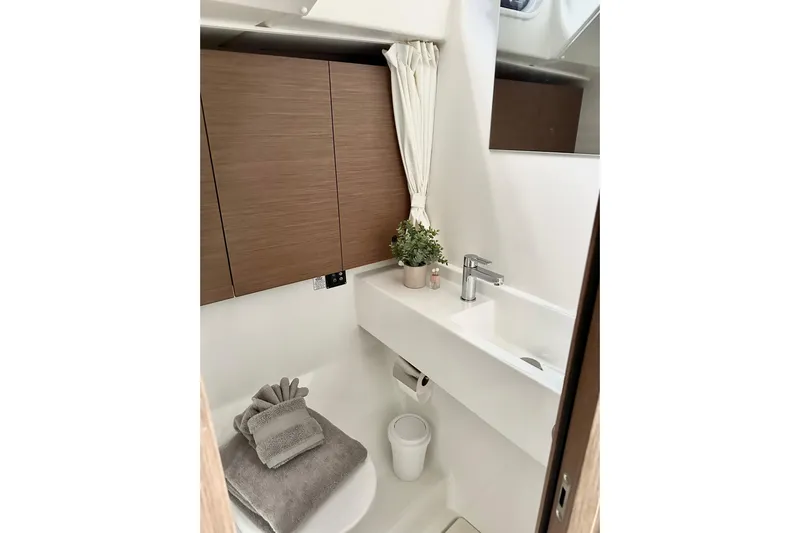 Sea Dawgs Yacht Photos Pics Modern bathroom in 2021 Beneteau Oceanis Yacht 54, featuring sleek design and wooden cabinetry.