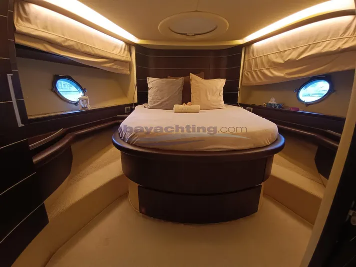  Yacht Photos Pics Luxurious bedroom interior of 2004 Azimut 68S yacht with round bed and porthole windows.